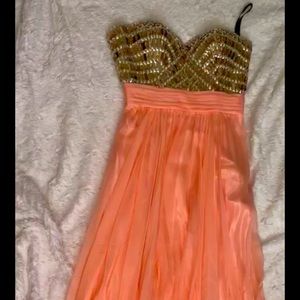 A formal pink long dress with bling on the top.